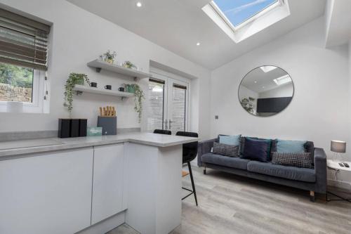 a kitchen and living room with a couch and a mirror at Prime Location, Modern 2BR House in Sheffield