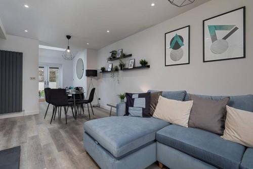 a living room with a blue couch and a dining room at Prime Location, Modern 2BR House in Sheffield