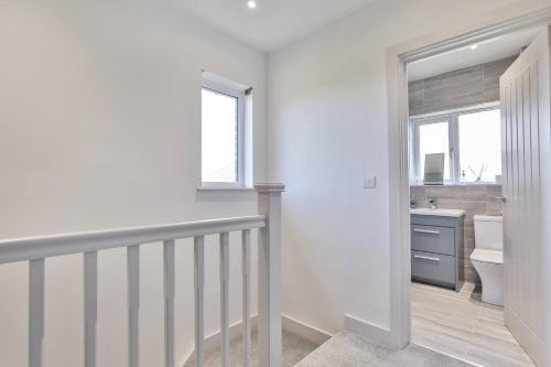 a white bathroom with a sink and a toilet at Modern, Cosy Whole House Wifi Close To Attractions in Sheffield