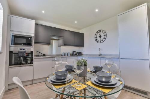 a kitchen with a glass table with chairs and a clock at Modern, Cosy Whole house WiFi close to attractions in Sheffield