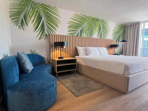 a bedroom with a bed and a blue chair at The Harrison Downtown Hollywood in Hollywood