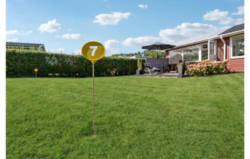 a yellow sign in the grass in front of a house at Holiday Home Haderslev 2 in Diernæs