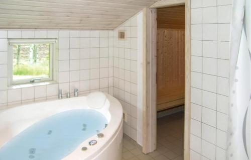 a bath tub in a bathroom with a window at Holiday Home Skovsgårdsvej in Hals