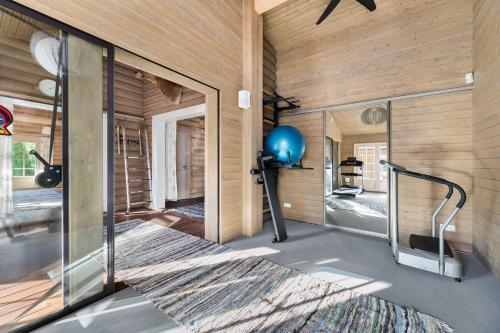 a room with a gym with a mirror at Woodland Retreat Lodge in Vallapalu
