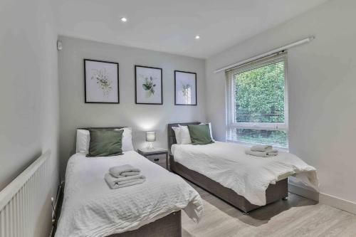 a bedroom with two beds and a window at 3 Br Bungalow Close To Peak District With Garden in Sheffield
