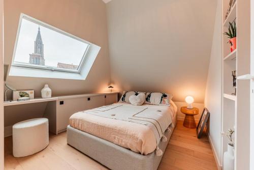 une chambre avec un grand lit avec une fenêtre dans l'établissement Le Petit Batelier - Strasbourg - Vue cathédrale, à Strasbourg