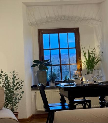 a dining room table with a window with wine glasses at Ferienwohnung Burg Hausen in Heimbach