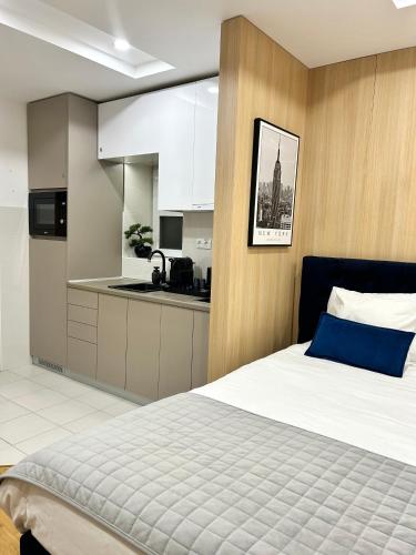 a bedroom with a large bed and a kitchen at Paradise Museum City Center in Belgrade