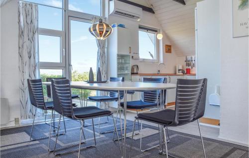 a table and chairs in a kitchen with a window at Holiday Home Ringkøbing With Fireplace Ii in Ringkøbing
