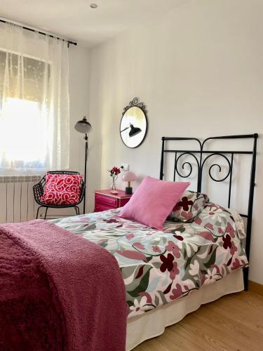 a bedroom with a bed with a pink pillow at VUT LOS CONDES Garaje privado in Zamora