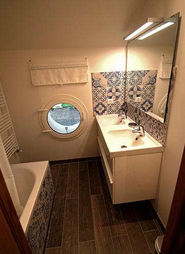 une salle de bain avec un lavabo, un miroir et une baignoire dans l'établissement Ferme de Pontaly, à Bailly