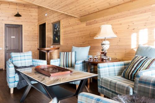 a living room with blue chairs and a table at Woodland Retreat Lodge in Vallapalu