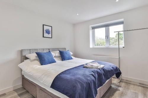 a bedroom with a large bed with blue pillows at Newly Renovated 3 Bed 2 Bath Apartment & Parking in Sheffield