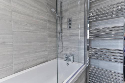 a bathroom with a shower and a bath tub at Newly Renovated 3 Bed 2 Bath Apartment & Parking in Sheffield