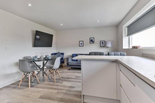 a kitchen and living room with a table and chairs at Newly Renovated 3 bed 2 bath Apartment & Parking in Sheffield