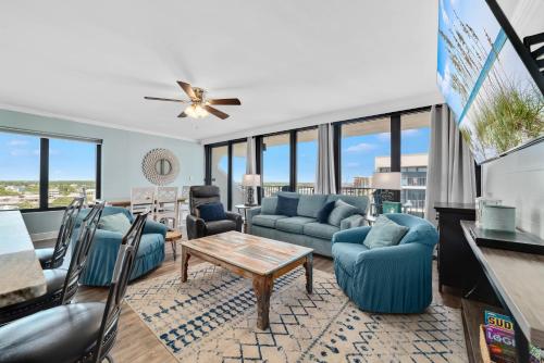 salon z niebieskimi kanapami i stołem w obiekcie Island Winds West Unit 870 w mieście Gulf Shores