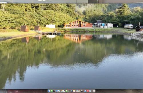 a view of a lake with a house in the background at Cozmo in Nikko