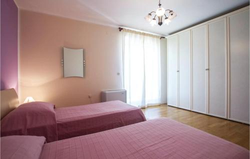 a bedroom with two beds and a chandelier at Cozy Home In Kapelica With Wifi in Raša
