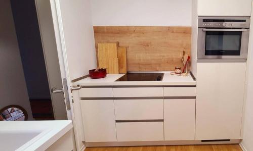 a white kitchen with a sink and a microwave at Ferien-und Monteurwohnung 'Friedersdorfer Mühle' in Pressig