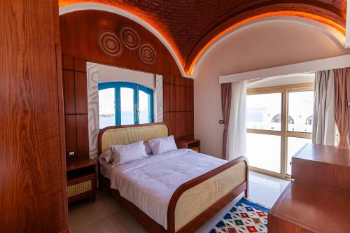 a bedroom with a bed and a large window at Aro Kato Nubian Guest House in Aswan