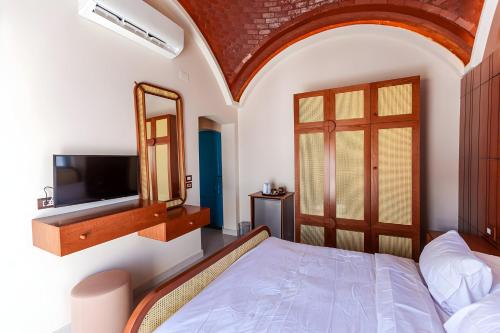 a bedroom with a bed and a mirror and a tv at Aro Kato Nubian Guest House in Aswan