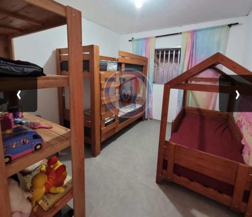 a bedroom with two bunk beds and a play room with at Casa em Mongaguá in Mongaguá