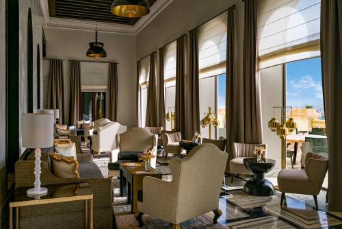 a living room with chairs and tables and windows at Fairmont Tazi Palace Tangier in Tangier