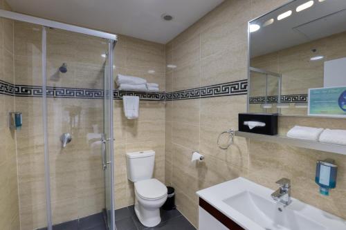 a bathroom with a toilet and a shower and a sink at Ramada by Wyndham, Hamilton City Center in Hamilton