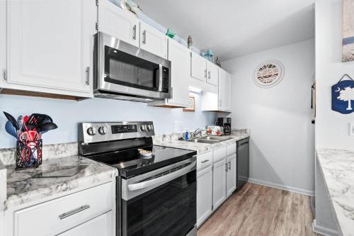 a kitchen with white cabinets and a stove top oven at 215 C2 GP-The Treehouse in Coffeyville