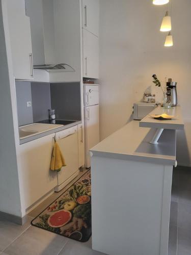 une cuisine avec des armoires blanches et un comptoir dans l'établissement Bel appartement à 300 mètres de la plage +parking, à Valras-Plage