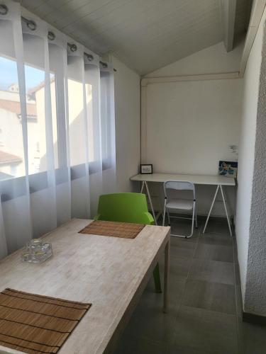 Cette chambre comprend une table, des chaises et un tableau blanc. dans l'établissement Bel appartement à 300 mètres de la plage +parking, à Valras-Plage