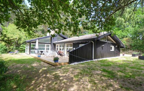 a black house with a porch and a deck at Beautiful Home In Ebeltoft With Sauna in Ebeltoft
