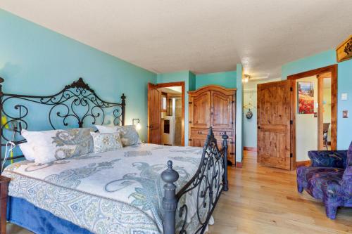 a bedroom with a large bed with blue walls at Multiple Decks, Solarium Sitting Room, Dog Friendly, Office Space in Woodland Park