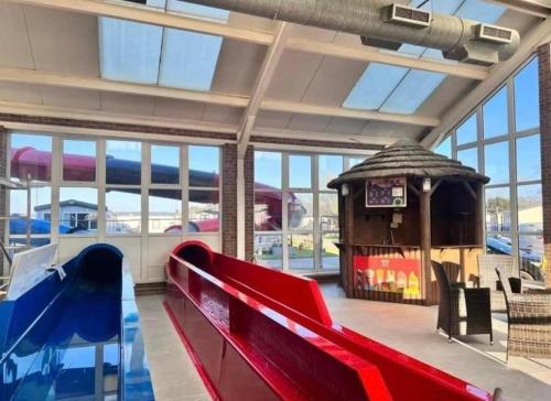 a large room with a red bench and a slide at Willerby, Peppy, Sycamore Walk, Lyons Robin Hood Holiday Park in Rhyl