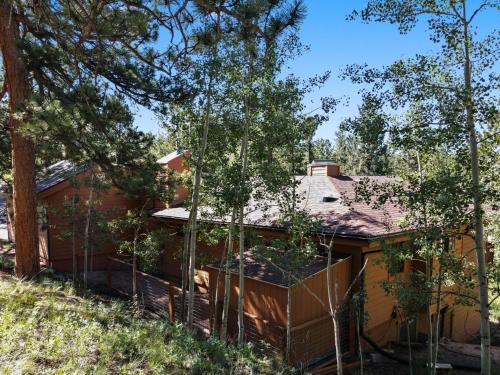 a house with a fence in front of it at Multiple Decks, Solarium Sitting Room, Dog Friendly, Office Space in Woodland Park