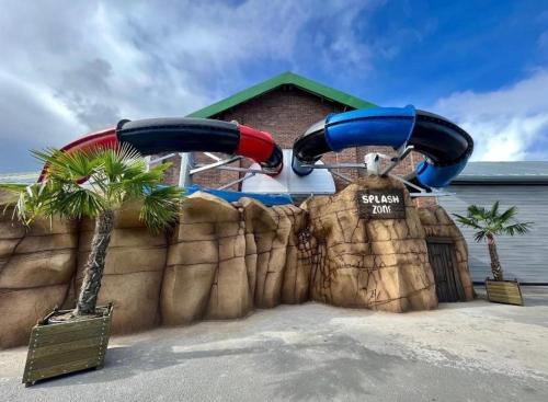 a water park with a water slide in front of a building at Willerby, Peppy, Sycamore Walk, Lyons Robin Hood Holiday Park in Rhyl