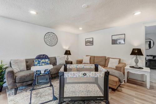 a living room with a couch and a baby crib at Cloud Ridge Cozy Suite w Fire Pit & Game Area in Colorado Springs