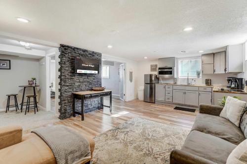 a living room with a couch and a stone fireplace at Cloud Ridge Cozy Suite w Fire Pit & Game Area in Colorado Springs