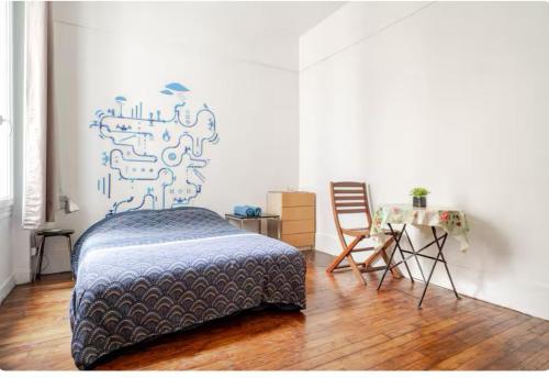 une chambre avec un lit et une table avec une chaise dans l'établissement Appartement Porte De Clichy, à Clichy
