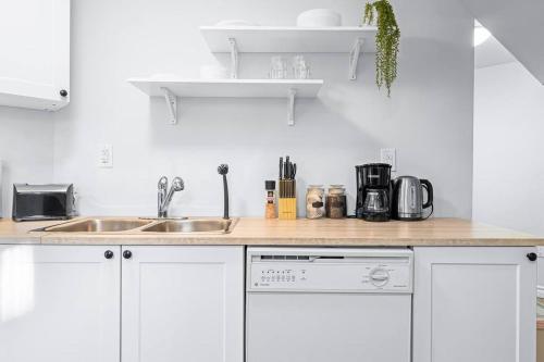 a kitchen with white cabinets and a sink at Charming 1-bed basement, Wi-Fi in Barrie