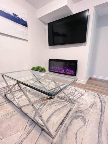 a glass table in a room with a tv on a wall at Charming 1-bed basement, Wi-Fi in Barrie