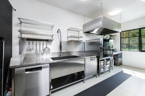 a kitchen with stainless steel counters and a sink at Woodland Retreat Lodge in Vallapalu