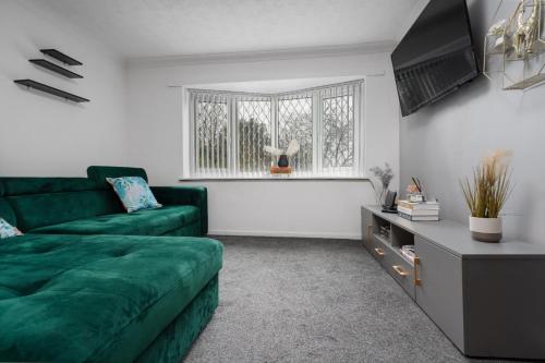 a living room with a green couch and a window at Hillcrest Apartments in Birmingham