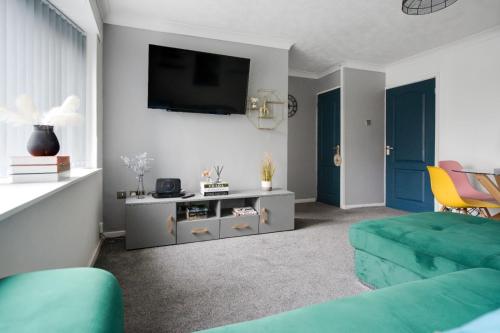 a living room with a green couch and a tv at Hillcrest Apartments in Birmingham