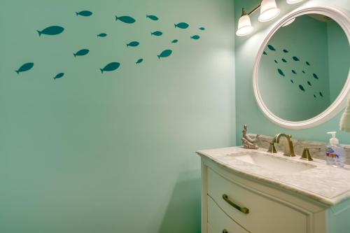 a bathroom with a sink and a mirror with fish decals at Golf Getaway with Pool Access Little River Home! in Little River