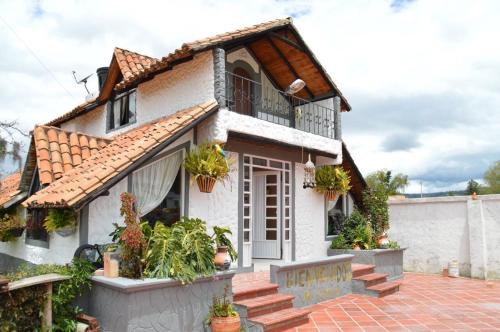 a house with potted plants in front of it at Cabaña campestre in Cómbita