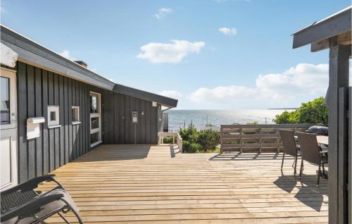 a wooden deck with chairs and the ocean in the background at Holiday Home Krokusvej in Egeskov