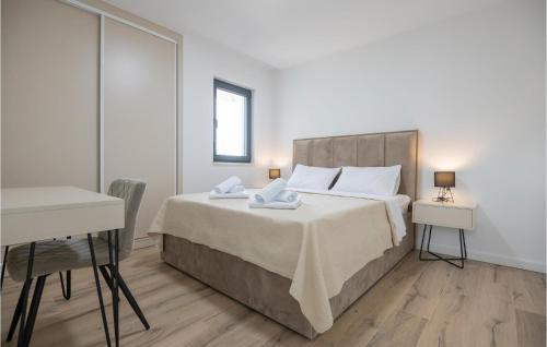 a bedroom with a large bed with a desk and a table at 4 Bedroom Stunning Home In Grubine in Grubine