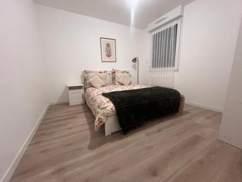 a white bedroom with a bed and a lamp at Appartement Chessy Disney wifi Parking Paris in Chessy