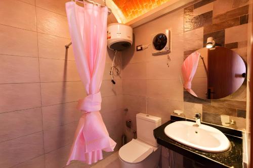 a bathroom with a pink shower curtain and a sink at Aro Kato Nubian Guest House in Aswan